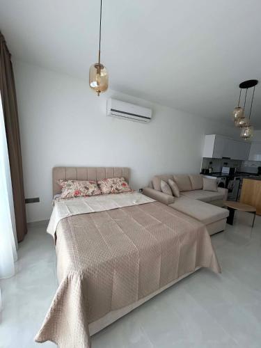 a bedroom with a bed and a couch at New Luxury Studio In Caesar Resort & Spa in Dherinia