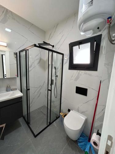 a bathroom with a shower and a toilet at New Luxury Studio In Caesar Resort & Spa in Dherinia