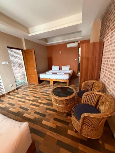 a room with a bed and chairs and a table at Kathmandu Metro Boutique Hotel in Kathmandu