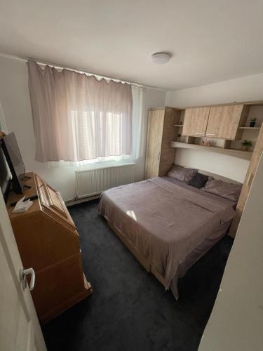 a small bedroom with a bed and a window at Apartament 2 camere R4 in Siret