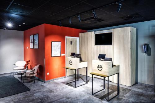 a room with two tables and a television on a wall at B&B Hotel Maribor in Maribor