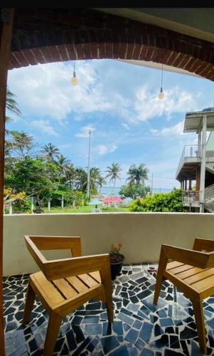 a patio with two chairs and a view of the ocean at Lushy Glorious Hotel in Matara