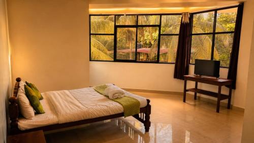 a bedroom with a bed and a tv and a window at Colors Fly Hotel in Colva