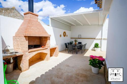 a patio with a brick fireplace in a house at Chalet Rural Alkaluz in Las Eras