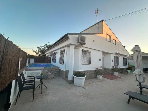 a white house with a patio and a pool at Chalet Rural Alkaluz in Las Eras