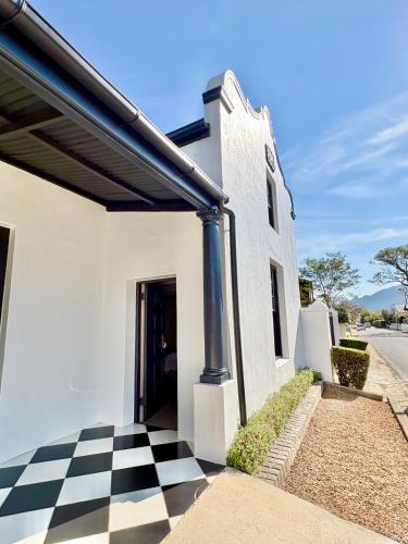 a white building with a black and white checkered floor at Mont d'Or Franschhoek in Franschhoek