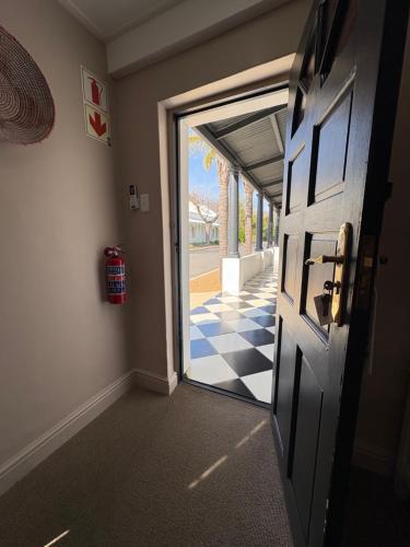 a door leading to a hallway with a checkered floor at Mont d'Or Franschhoek in Franschhoek
