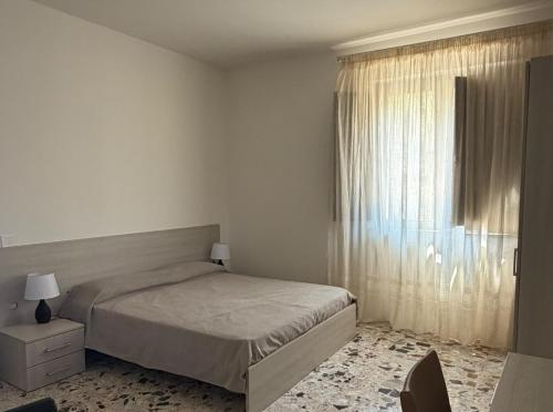 a bedroom with a bed and a large window at Dimora Guariglia in San Mauro Cilento
