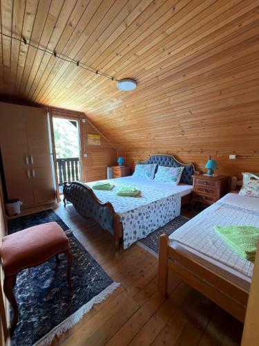 a bedroom with two beds and a wooden ceiling at Dedinski Raj in Golubac
