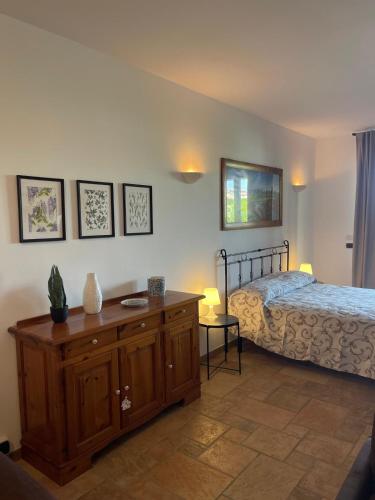 a bedroom with a bed and a wooden dresser at La Corte delle Marche in Osimo