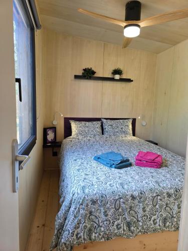 a bedroom with a bed with two bags on it at La tiny de Miss Purple in Chantelle