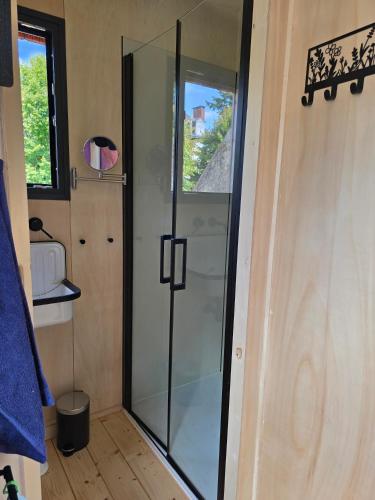 a glass shower in a small bathroom with a window at La tiny de Miss Purple in Chantelle