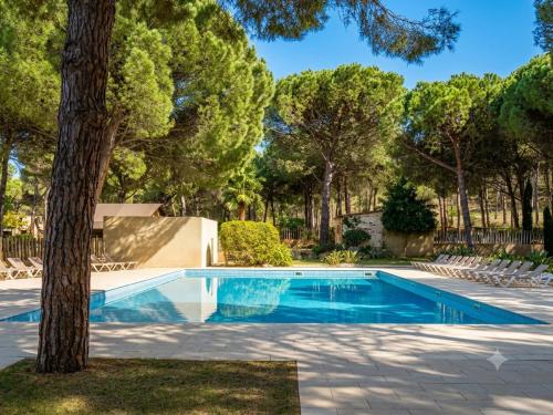 a swimming pool in a yard with a tree at wecamp L'Escala Punta Milà in L'Escala