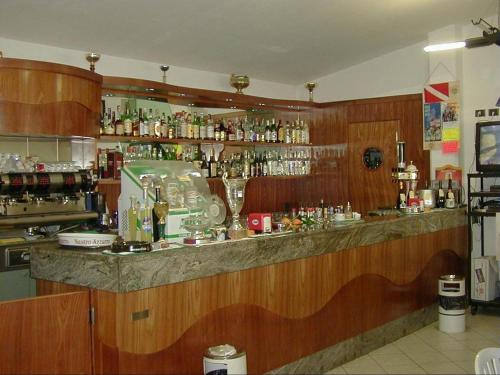 a bar in a restaurant with a counter with alcohol at Villaggio Turistico Sole e Mare in Nisporto