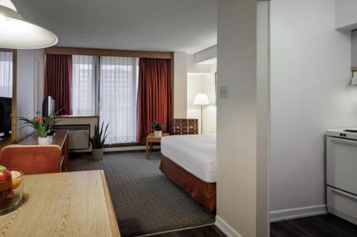 a hotel room with a bed and a kitchen at Cartier Place Suite Hotel in Ottawa