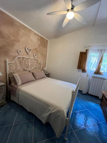 a bedroom with a bed and a ceiling fan at I Suoni di Valle Martina in Poderia