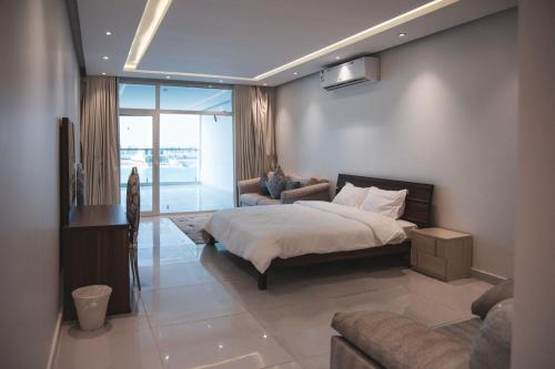 a bedroom with a bed and a couch at فيلا تولاي in Dahaban
