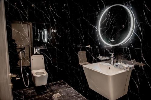 a black bathroom with a sink and a toilet at فيلا تولاي in Dahaban