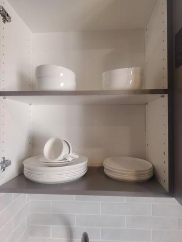 a shelf with plates and bowls in a kitchen at BlackBrick2 in Johannesburg