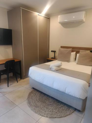 a bedroom with a large bed with a desk and a bedskirtspectspectspects at BlackBrick2 in Johannesburg