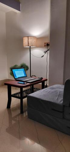 a laptop computer sitting on a table next to a bed at Pipits cozynest in Tezpur