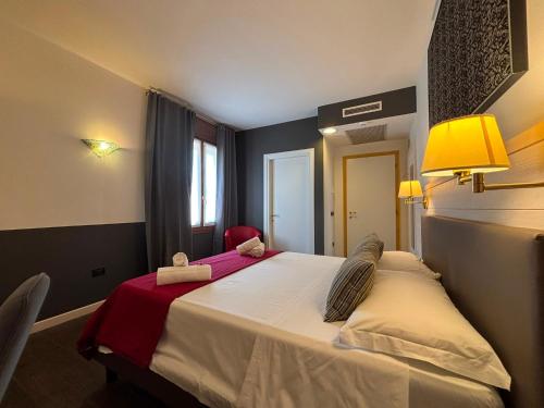 a bedroom with a large bed with a red blanket at Damodoro Hotel in Pordenone