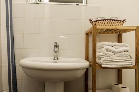 a bathroom with a sink and a basket of towels at Olmitos 3, Casa-Palacio Real Piedad in Cehegín