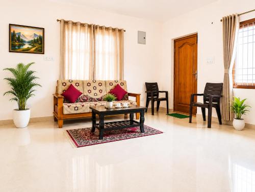a living room with a couch and a table at SLS Homestay - Luxury AC Service Apartments 1BHK, 2BHK, 3BHK - Direct Flyover to Alipiri Tirumala Gate - Walk to PS4 Pure Veg Restaurants, Supermarkets - Near to National Highway & Padmavathi Amma Temple - Modular Kitchen, Living room -Free Superfast Wifi in Tirupati