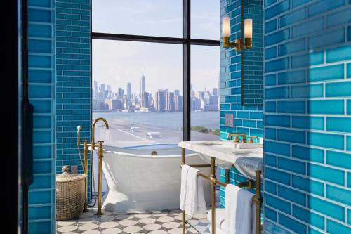 a bathroom with a tub and a view of the city at Arlo Williamsburg in Brooklyn