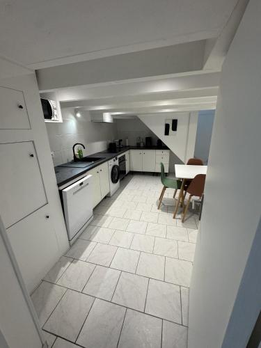 a kitchen with white cabinets and a table and chairs at Sam's cocoon in Vicq-sur-Nahon