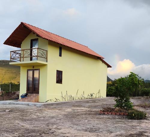 ein kleines gelbes Haus mit rotem Dach in der Unterkunft Chalé CauMô in Palmeiras