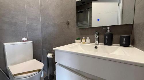 a bathroom with a white sink and a toilet at Bela House, By Home Match in Setúbal