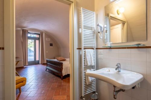 a bathroom with a sink and a room with a bed at Relais Corte Baruzzo in Volta Mantovana