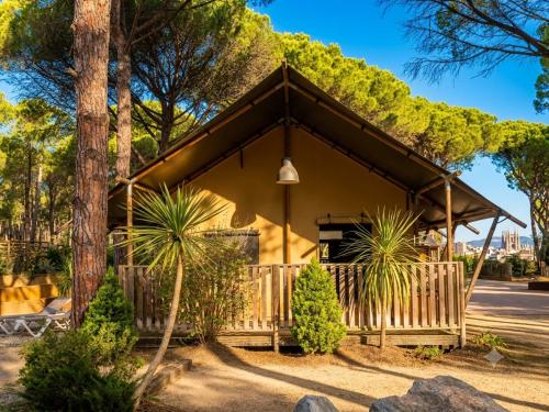 a yellow house with a fence and trees at wecamp L'Escala Punta Milà in L'Escala
