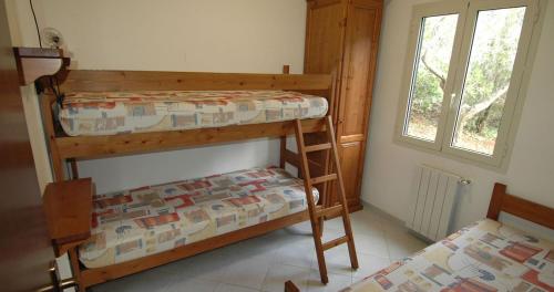 two bunk beds in a room with a window at Villaggio Turistico Sole e Mare in Nisporto
