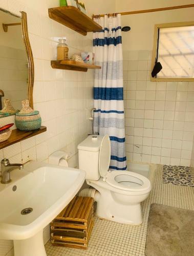 a bathroom with a white toilet and a sink at Malika Surf House in Dakar