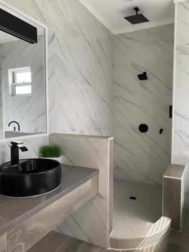 a bathroom with a black sink and a mirror at The Ansen Place in Belmopan