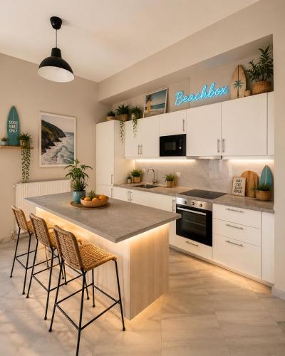 a kitchen with white cabinets and a island with bar stools at BeachBox in Piraeus