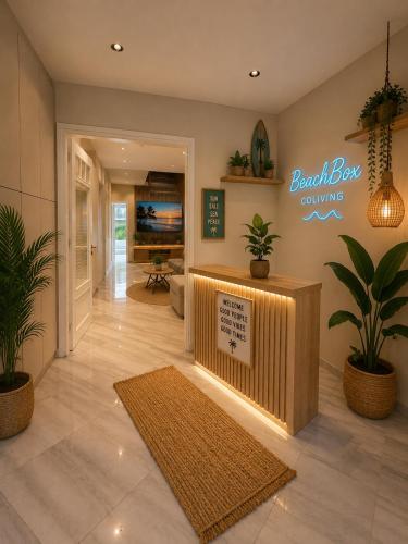 a lobby with a reception desk and potted plants at BeachBox in Piraeus