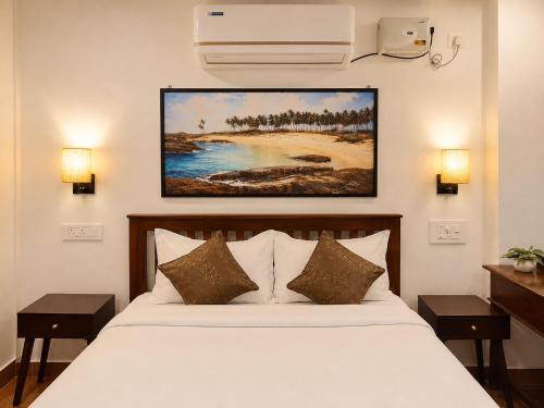 a bedroom with a bed and a painting on the wall at Udupi River Inn in Kalyānpur
