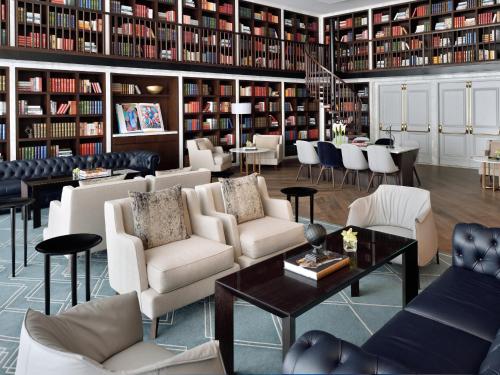 a library with couches and chairs and a table at Kempinski The Boulevard Dubai in Dubai