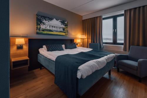 a hotel room with a bed and a chair at Hotel Haikko Manor & Spa in Porvoo