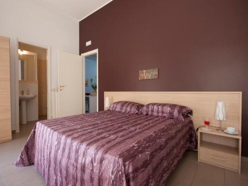 una camera con un grande letto con copriletto viola di Vado Al Massimo a Palermo