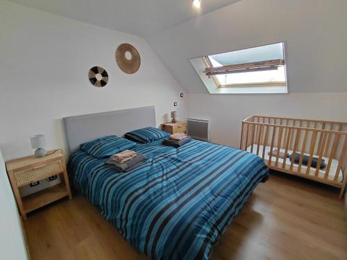a bedroom with a large bed and a crib at Le brin d'air Mayennais in Saint-Julien-du-Terroux