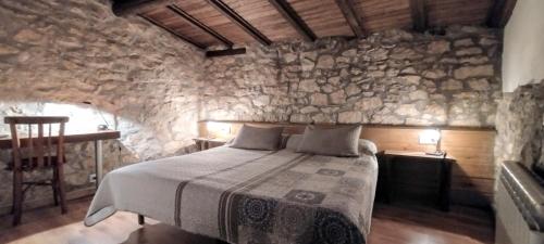 a bedroom with a bed in a stone wall at Habitació doble Àger in Àger