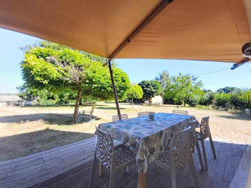 a table and chairs under an umbrella on a deck at Lodge La Vie Douce in Vigeois