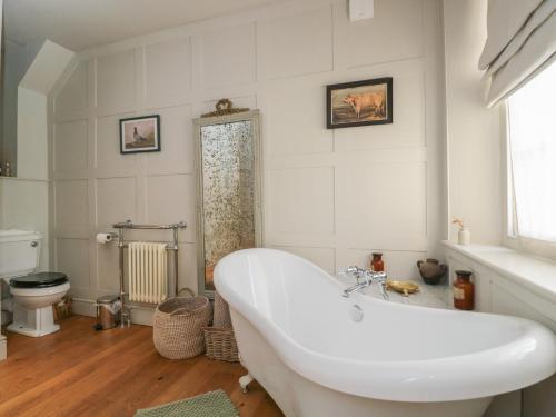 a white bathroom with a tub and a toilet at Cotswold House in Moreton in Marsh