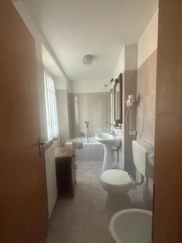 a bathroom with a toilet and a sink and a tub at Villa Coppa Hotel in Dazio