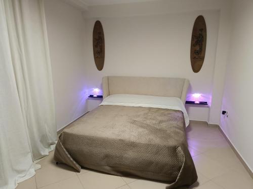 a bedroom with a bed with lights on the wall at Aura in Scilla
