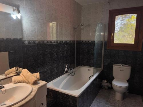 a bathroom with a tub and a toilet and a sink at Casa Peregil in Perelló